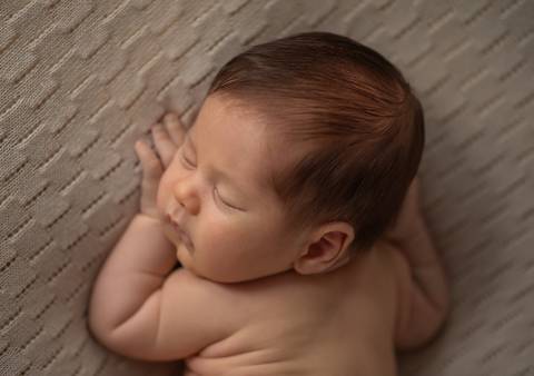 bebê deitado em posição de bruços'