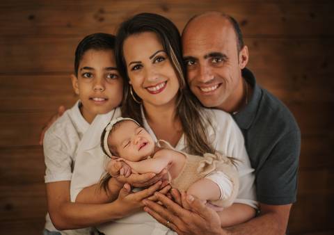 família sorrindo em ensaio newborn'