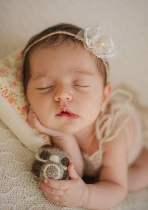 bebê segurando câmera em ensaio newborn'