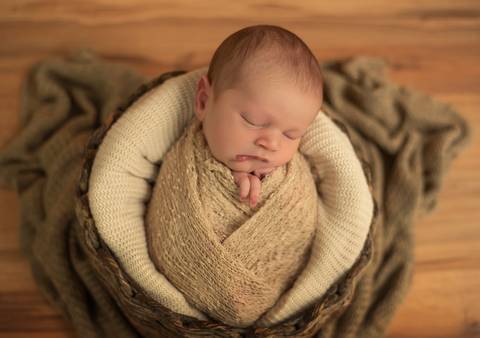 bebê enroladinho dentro do cestinho'