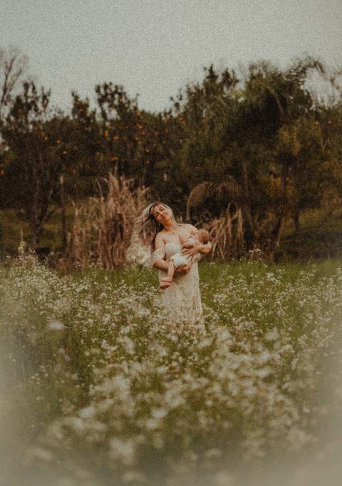 mulher com cabelos esvoaçantes amamentando'