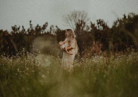 Mãe Aline Fontes amamentando no meio das flores'