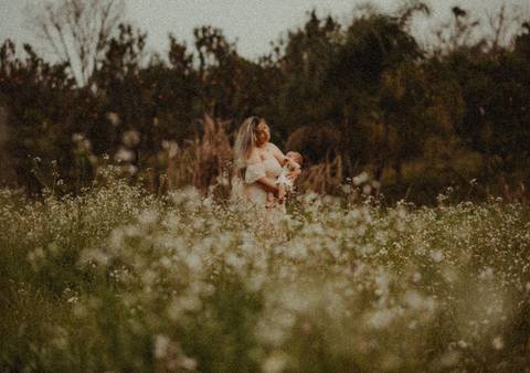 campo florido e mãe amamentando'