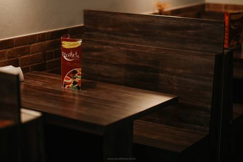 Imagem do exterior da pizzaria em Bento Gonçalves à noite.'