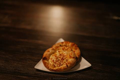 Foto de pizza com massa crocante e ingredientes frescos na pizzaria em Bento Gonçalves.
Close de pizza de calabresa com queijo derretido na pizzaria da Serra Gaúcha'