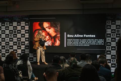 Palestrante discutindo técnicas de conexão emocional na fotografia newborn.
'