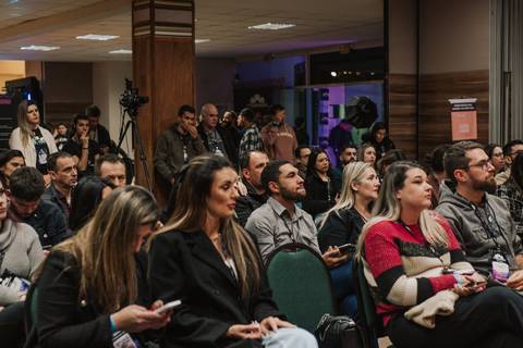 Público ouvindo palestra sobre técnicas de iluminação para fotos newborn.
'