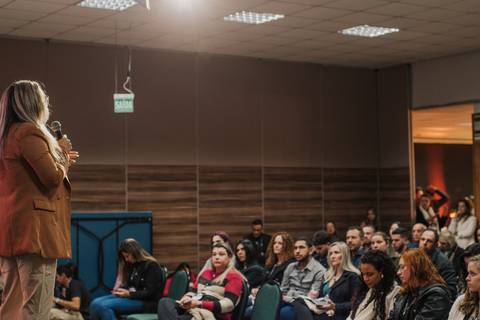 Fotógrafo ajustando cenário para ensaio newborn durante workshop.
'