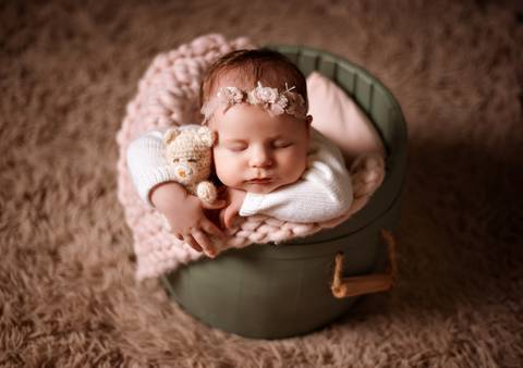Foto de bebê com os olhinhos fechados, em posição segura e confortável.'