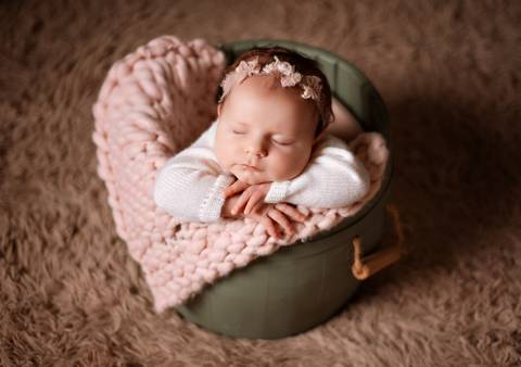 Detalhe das mãozinhas de bebê em um retrato suave e delicado.'