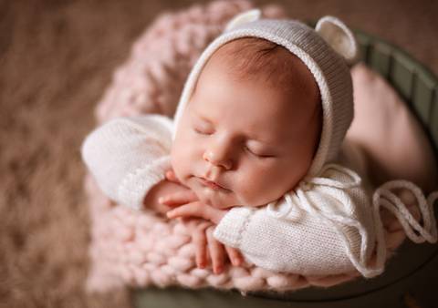 Expressão tranquila de bebê em pose aconchegante'