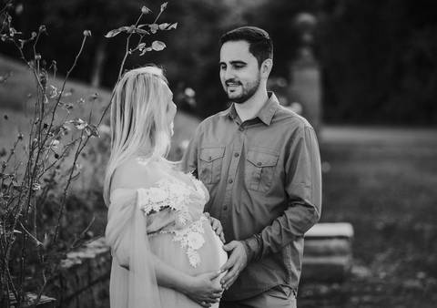 Casal se olhando com carinho, de mãos dadas entre os parreirais. Esperança e unidade no Vale dos Vinhedos.'