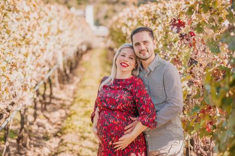 Casal trocando olhar carinhoso em meio às árvores, com cenário rústico e elegante de Bento Gonçalves ao fundo.'