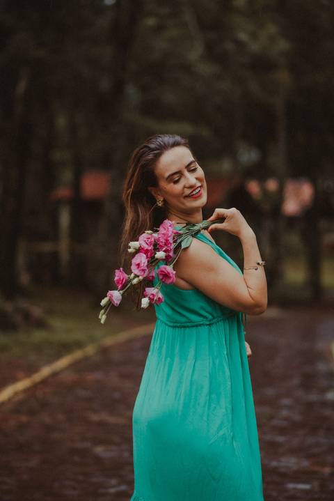 Mulher caminhando descalça na floresta durante o ensaio na chuva, simbolizando reconexão e liberdade.'