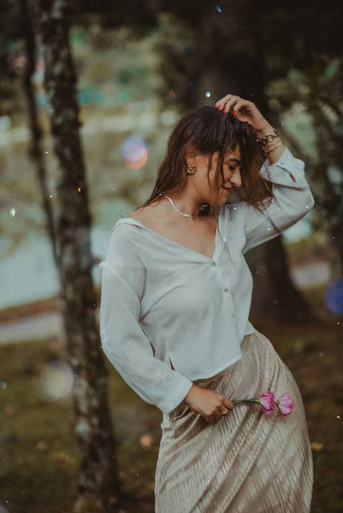 Mulher celebrando o agora em ensaio chuvoso, retratando empoderamento e autoamor.'