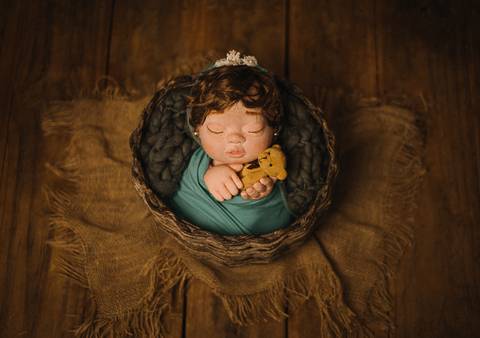 Boneca Jolie em pose vertical com wrap verde, representando exercícios de treino com boneca reborn para fotógrafos de recém-nascidos.'