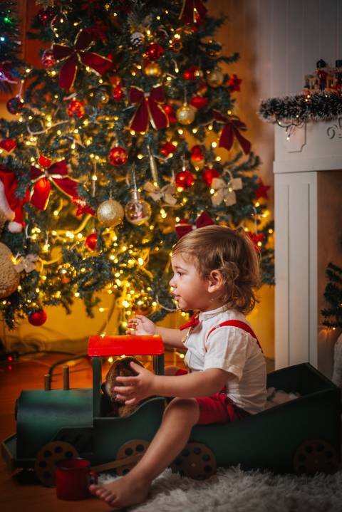 Ensaio de Natal para famílias com decoração dourada e vermelha.'