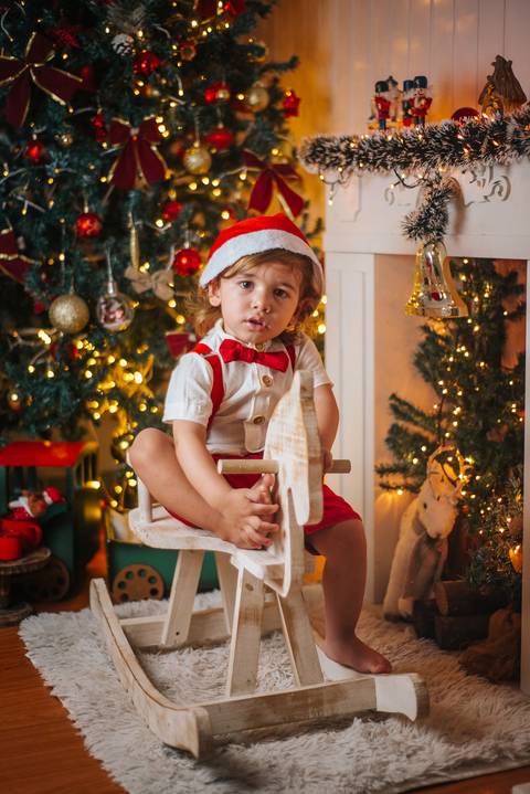 Sessão de Natal com paleta tradicional e clima acolhedor.'