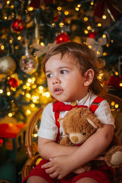 Foto infantil natalina com ambientação rústica e charmosa.'