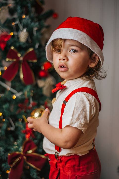 Evan em sessão de Natal com estética delicada e luz suave.'