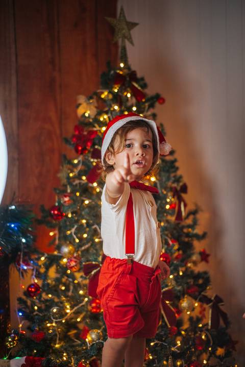 Ensaio gestante de Natal com luzes e decoração aconchegante.'