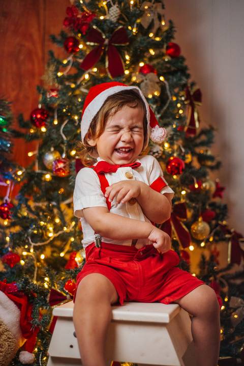 Sessão gestante com árvore iluminada ao fundo.'