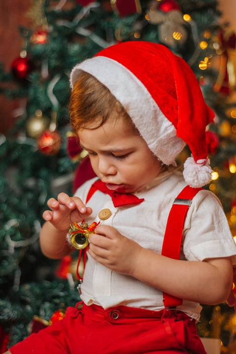 Foto de casal em clima natalino com luzes ao fundo.'