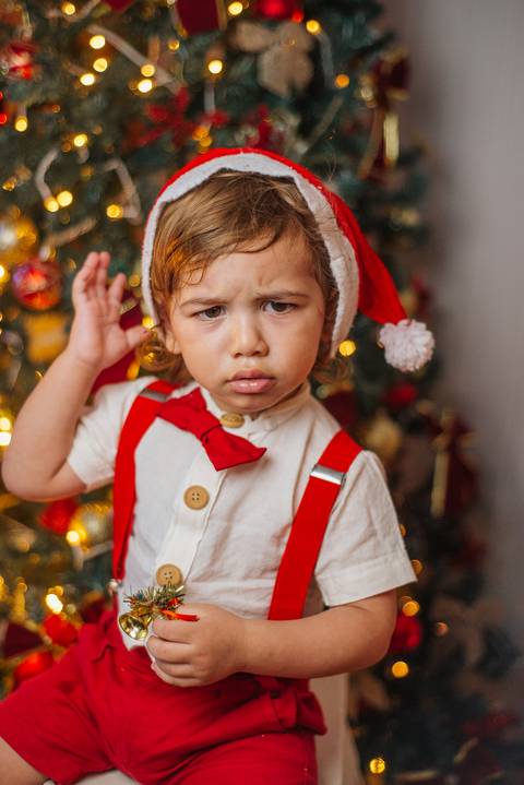 Ensaio de Natal do Evan com detalhes dourados e vermelhos.'