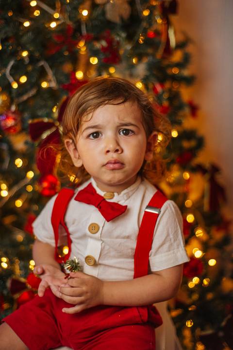 Sessão de Natal com casal em ambiente rústico iluminado.'