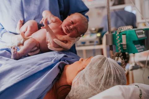 Primeiros movimentos da bebê após o nascimento, cobertura fotográfica de parto em Bento Gonçalves RS.'