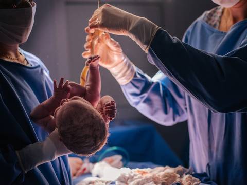 Recém-nascida sendo apresentada pela equipe médica logo após o nascimento em cesariana no Hospital Tacchini.'