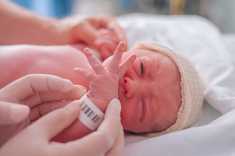 Primeiros cuidados com a recém-nascida após o parto, fotografia de nascimento em ambiente hospitalar.'