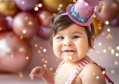 Retrato de bebê em ensaio Smash the Cake usando acessório temático, expressão alegre e fotografia infantil em Farroupilha.'