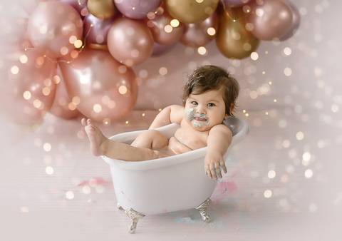 Ensaio Smash the Cake com bebê em banheira cenográfica, proposta leve e divertida para comemoração de 1 ano.'