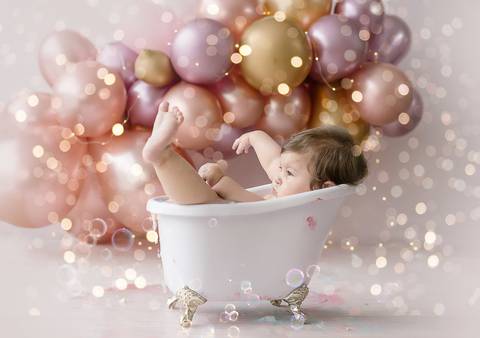 Bebê em ensaio Smash the Cake dentro de banheira branca, cenário clean e fotografia infantil em Farroupilha.'