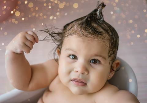 Retrato de bebê molhando o cabelo em ensaio Smash the Cake, expressão curiosa, fotografia infantil espontânea em estúdio.'