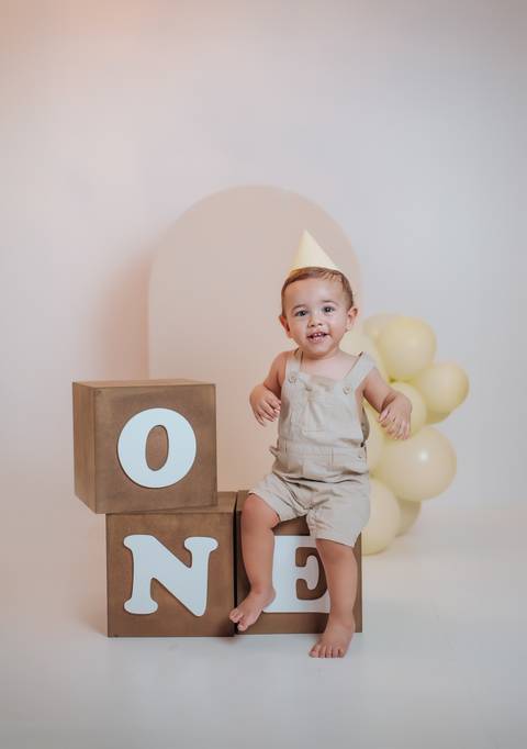 Fotografia infantil de 1 ano com bebê em estúdio claro e cenário delicado'