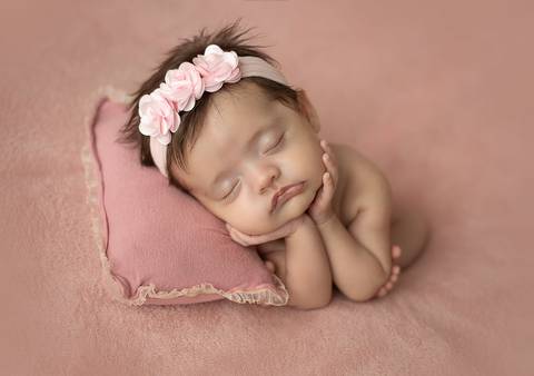 Ensaio old newborn com bebê prematura de 3 meses apoiada em almofada, cenário rosado e condução cuidadosa'