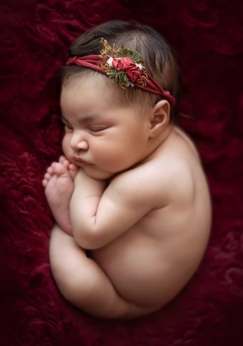 Bebê recém-nascida em ensaio newborn tradicional, close suave destacando traços do bebê'