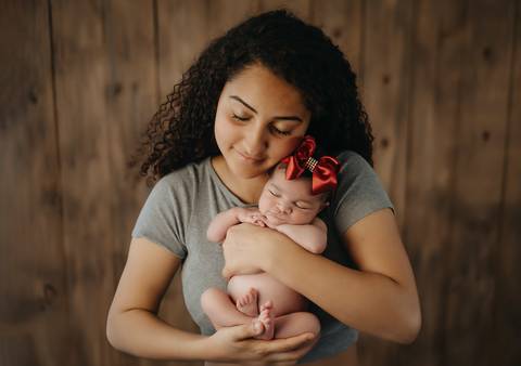 Bebê recém-nascida em ensaio newborn com os pais, fotografia de família em estúdio'