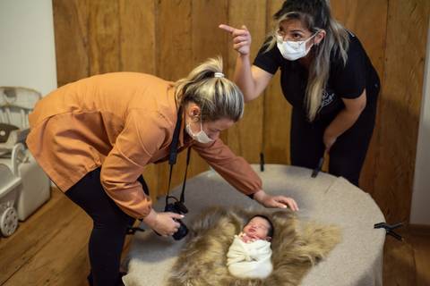Aline Fontes orientando Priscilla Patzlaff, fotógrafa newborn em Bento Gonçalves, durante mentoria prática sobre preparo do cenário e conforto do bebê.'