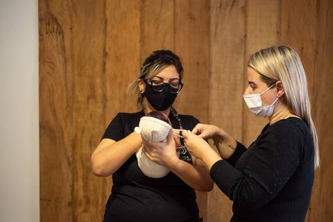 Aline Fontes orientando Priscilla Patzlaff, fotógrafa newborn em Bento Gonçalves, sobre postura e segurança no atendimento ao bebê.'