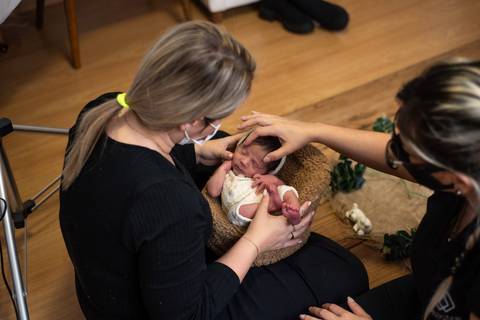Aline Fontes orientando Priscilla Patzlaff, fotógrafa especialista em newborn, durante prática de condução e acolhimento do bebê.'