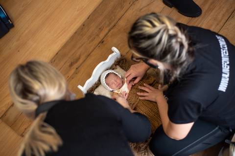 Mentoria newborn em estúdio em Bento Gonçalves, com Aline Fontes orientando Priscilla Patzlaff Fotografias no posicionamento do recém-nascido.'