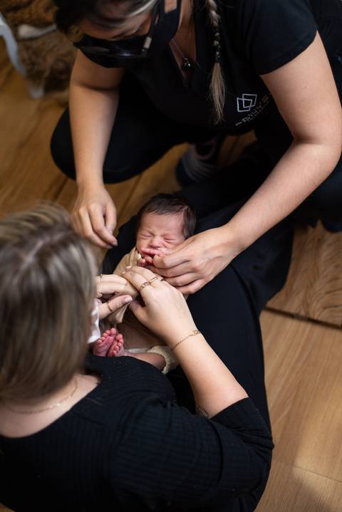 Mentoria prática de fotografia newborn com Aline Fontes e Priscilla Patzlaff Fotografias, ajustando pose e conforto do bebê em estúdio.'
