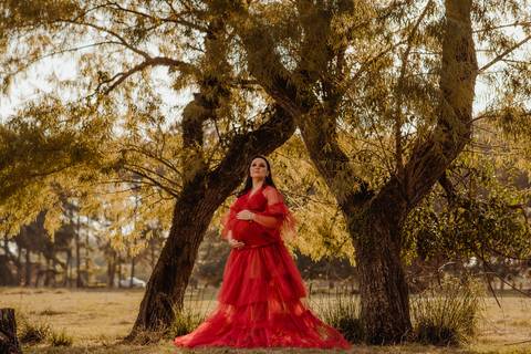 gestante com vestido vermelho em ensaio fotográfico externo'