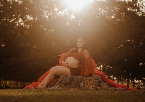 ensaio de gestante ao pôr do sol com vestido vermelho'