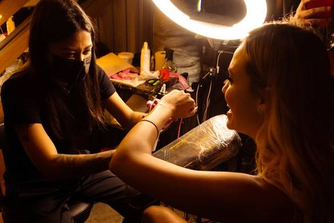 sarah andrade fazendo tatuagem no evento em sp do lançamento das peças de jóias dela'
