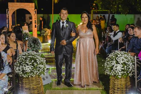 noivo entrando com sua mãe pela passarela de flores'