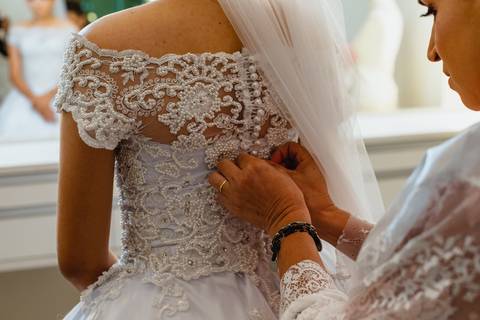 fotografia da mãe da noiva fechando seu vestido, no salão de beleza Harmonize em Rondonópolis-MT, fotografo Sergio Simões.'